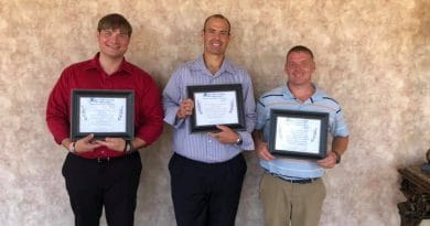 3 men holding certificates